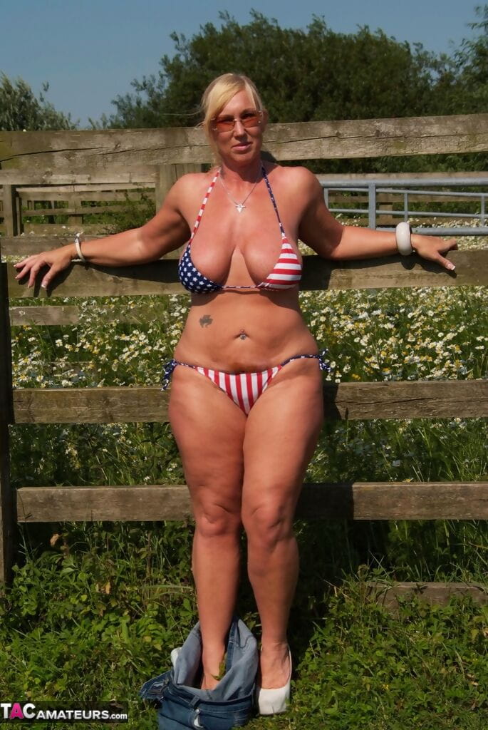 Busty mature slut Melody sheds bikini top outdoors to sun massive tits page 1