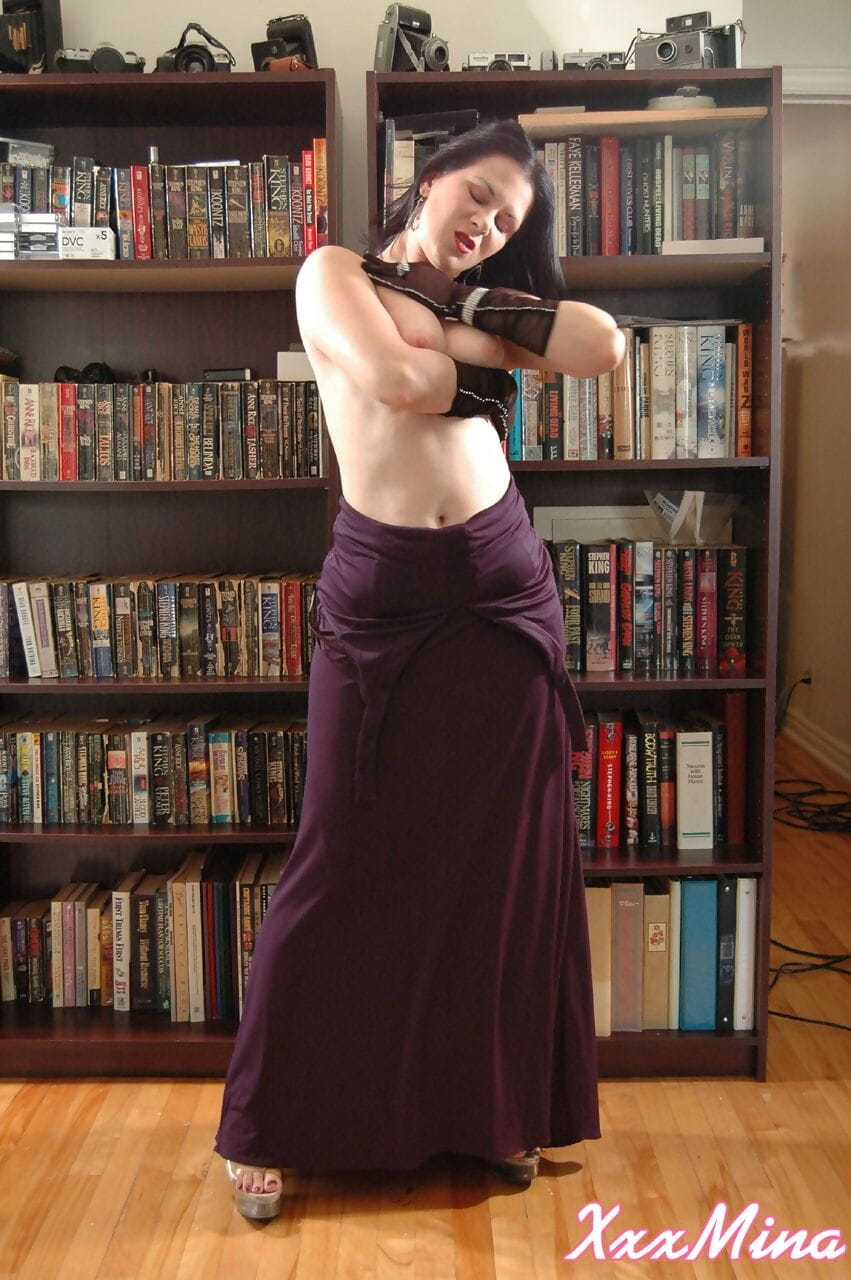 Amateur model Mina Gorey strips naked in gloves and heels afore a bookcase page 1