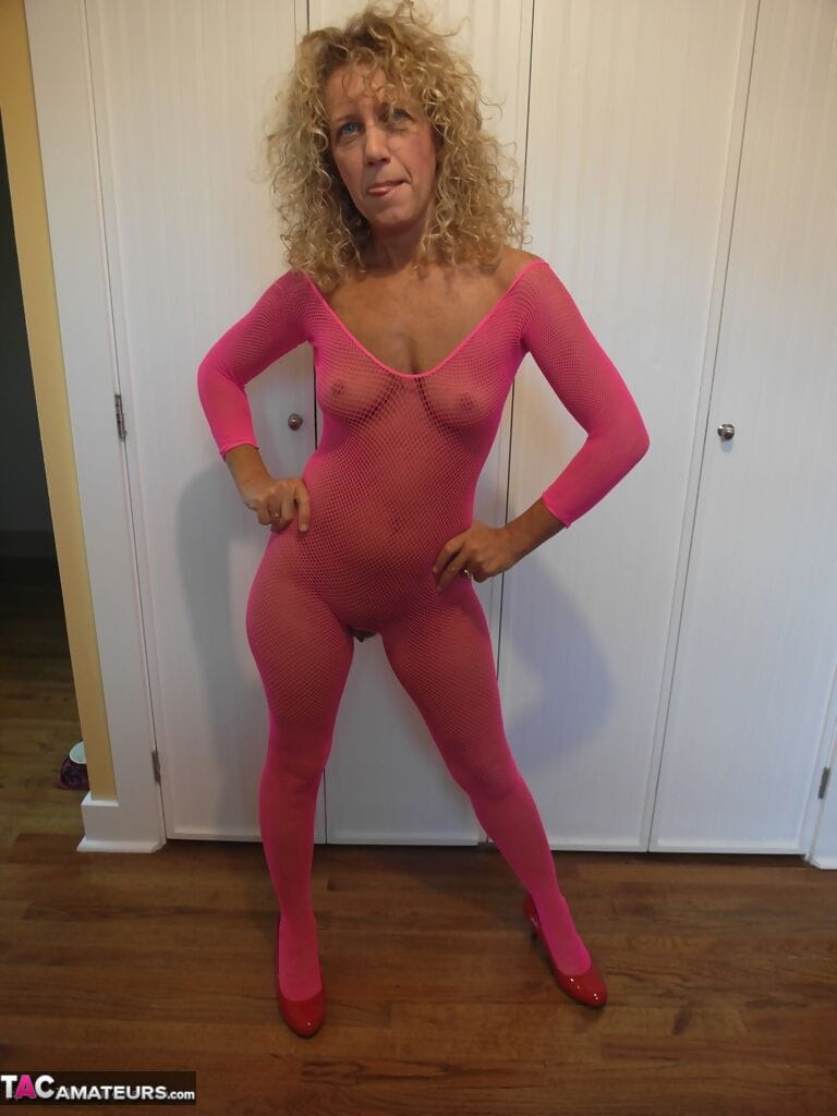 Mature lady with curly blonde hair frees her boobs from pink bodystocking page 1