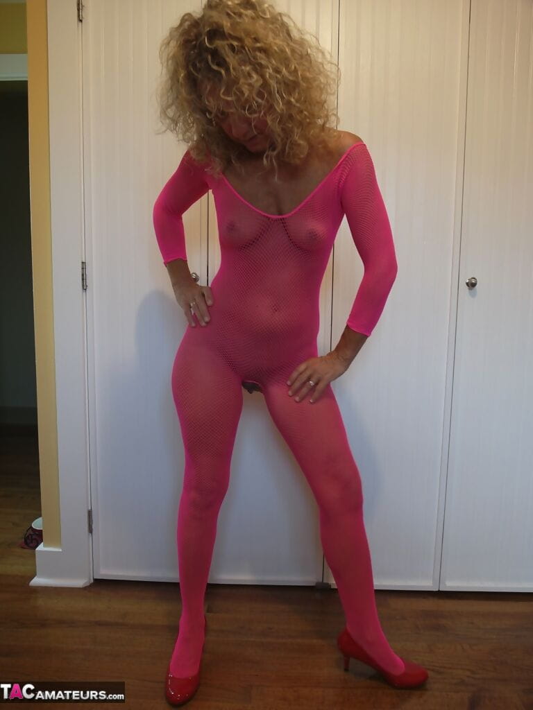Mature lady with curly blonde hair frees her boobs from pink bodystocking page 1