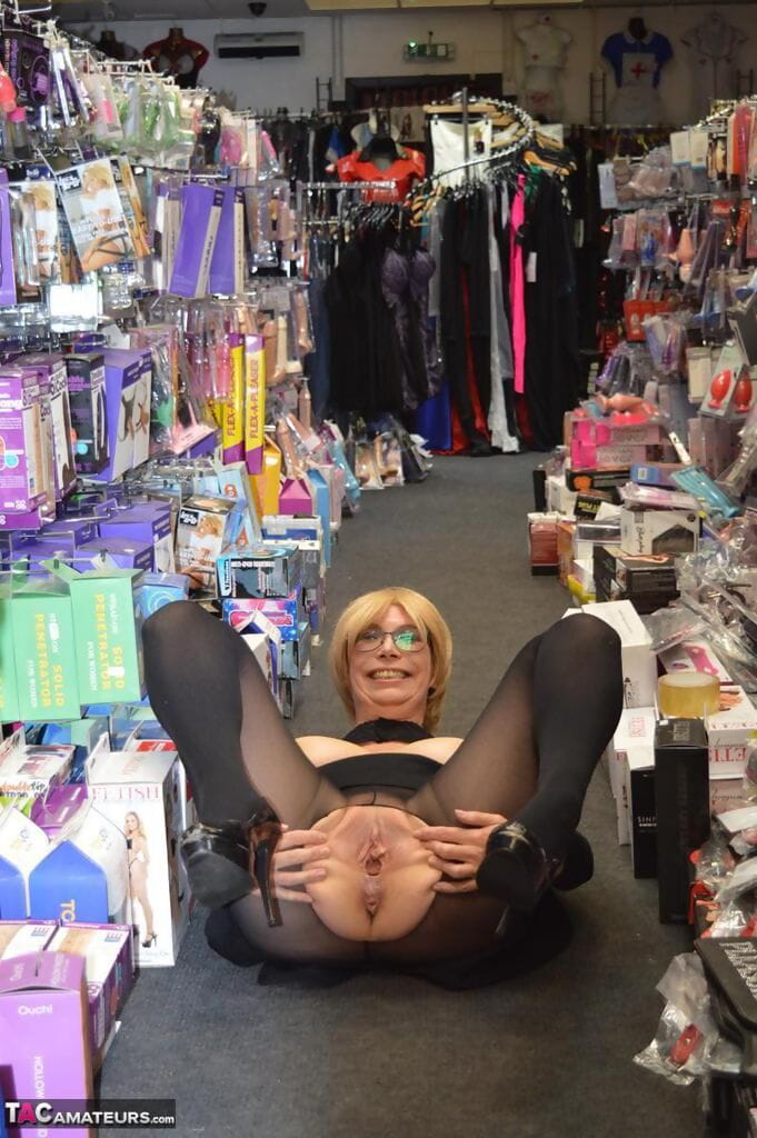 Mature woman flashes her tits and twat on sidewalk and in sex shop page 1