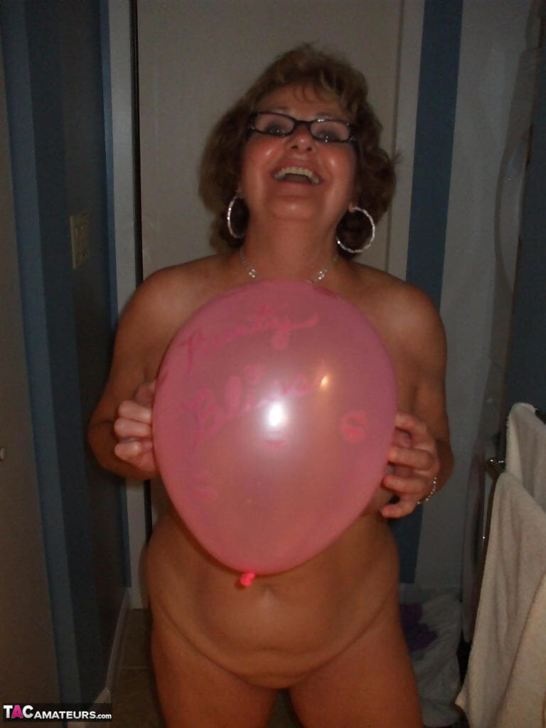 Mature lady models totally naked while playing with balloons page 1