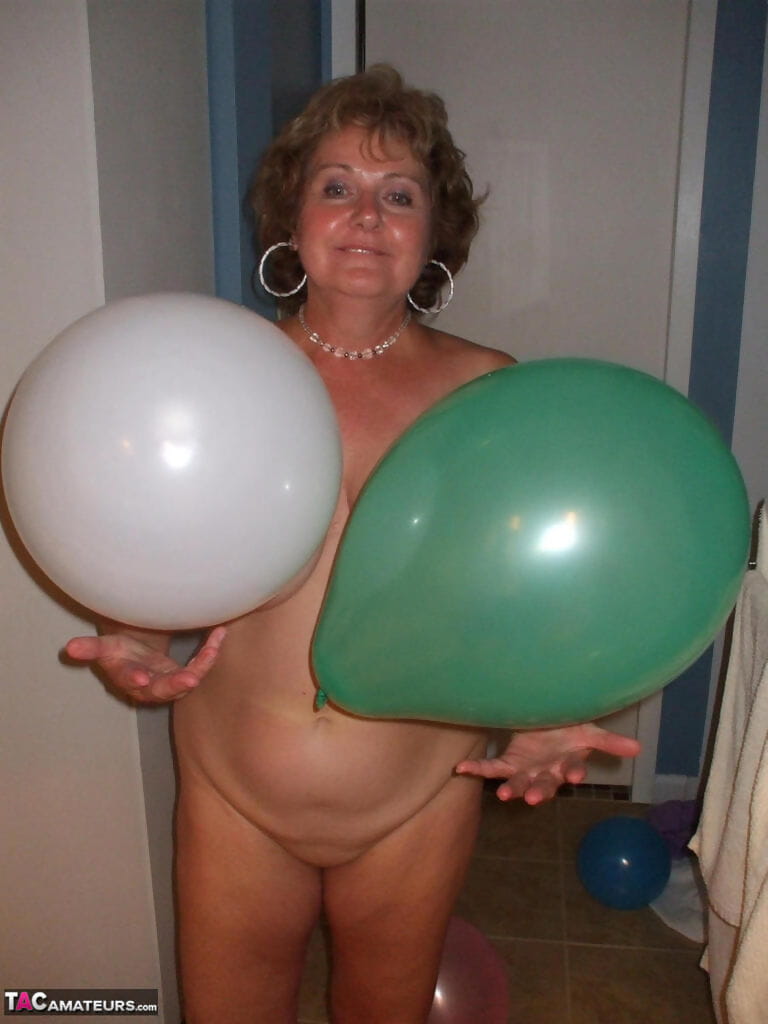Mature lady models totally naked while playing with balloons page 1
