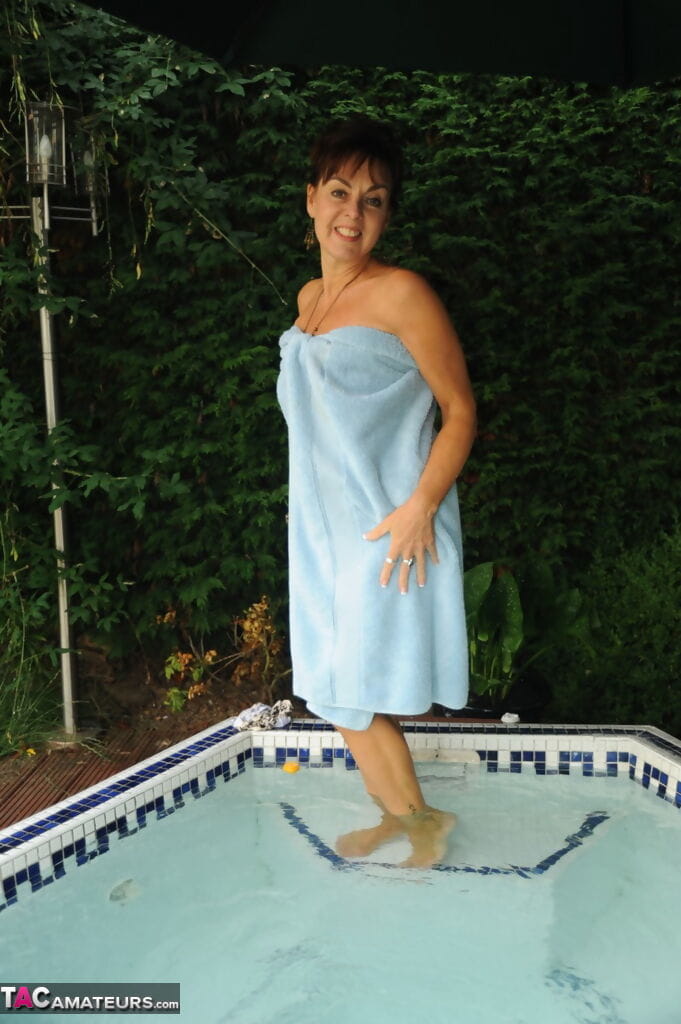 Mature lady Georgie relaxes her tan lined body in outdoor hot tub page 1