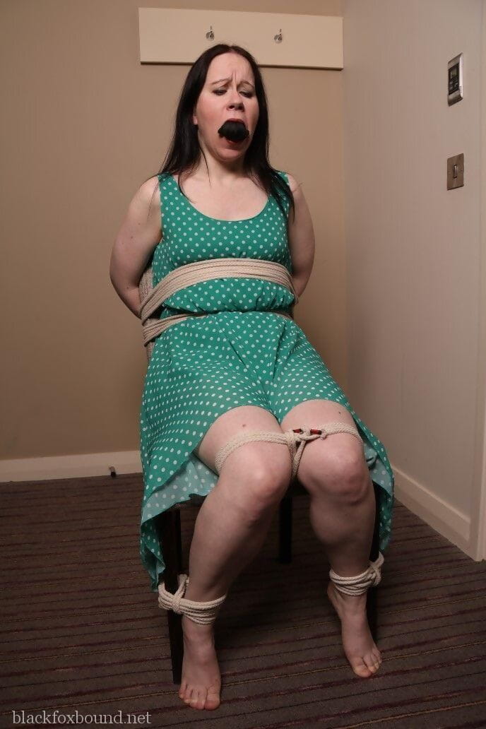 Distressed mature woman in polka-dot dress tied up & gagged for BDSM fun page 1