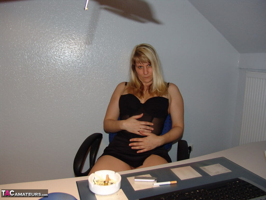 Mature amateur smokes a cigarette before masturbating in office chair page 1